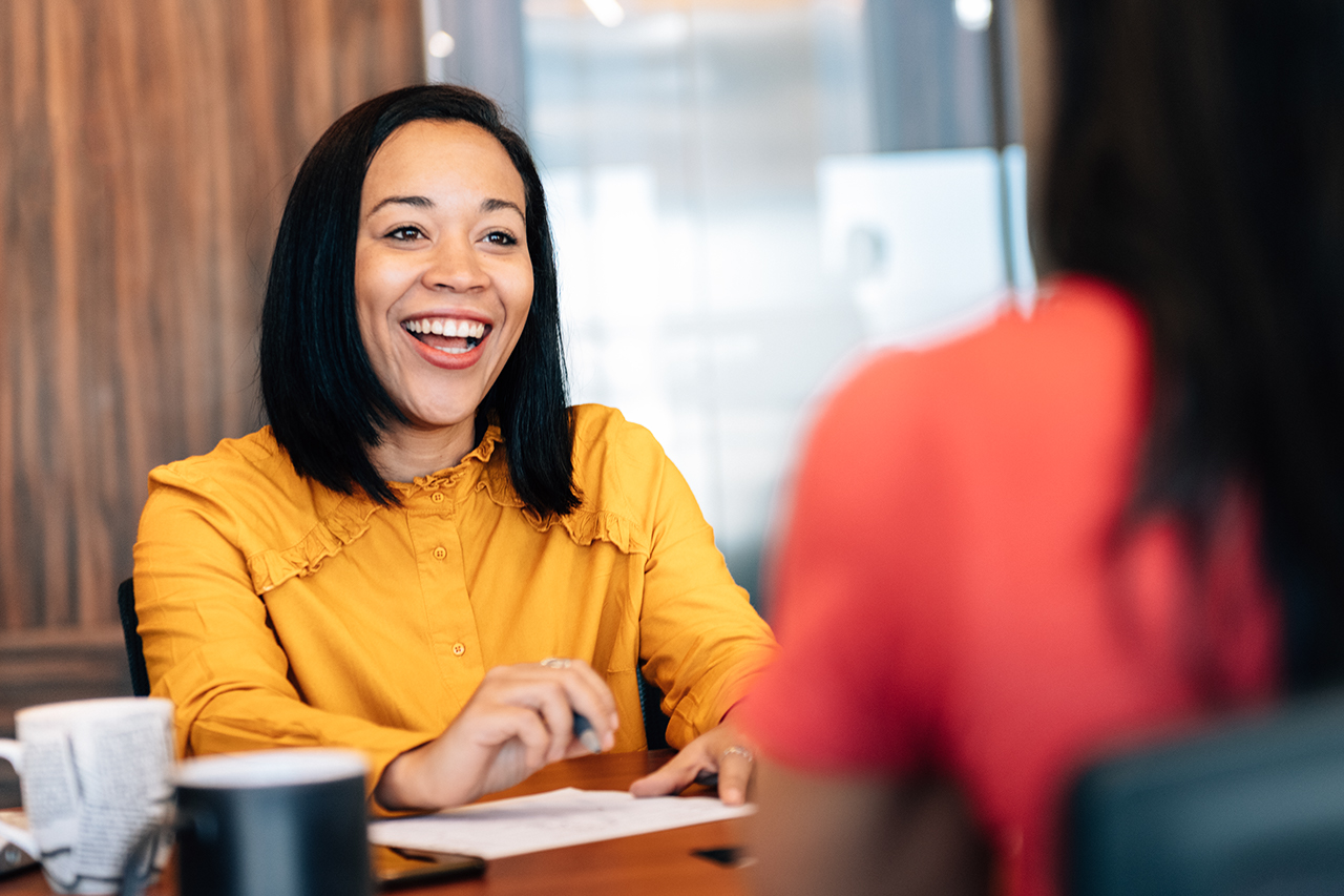 One to one business meeting, businesswoman in focus talking to colleague.