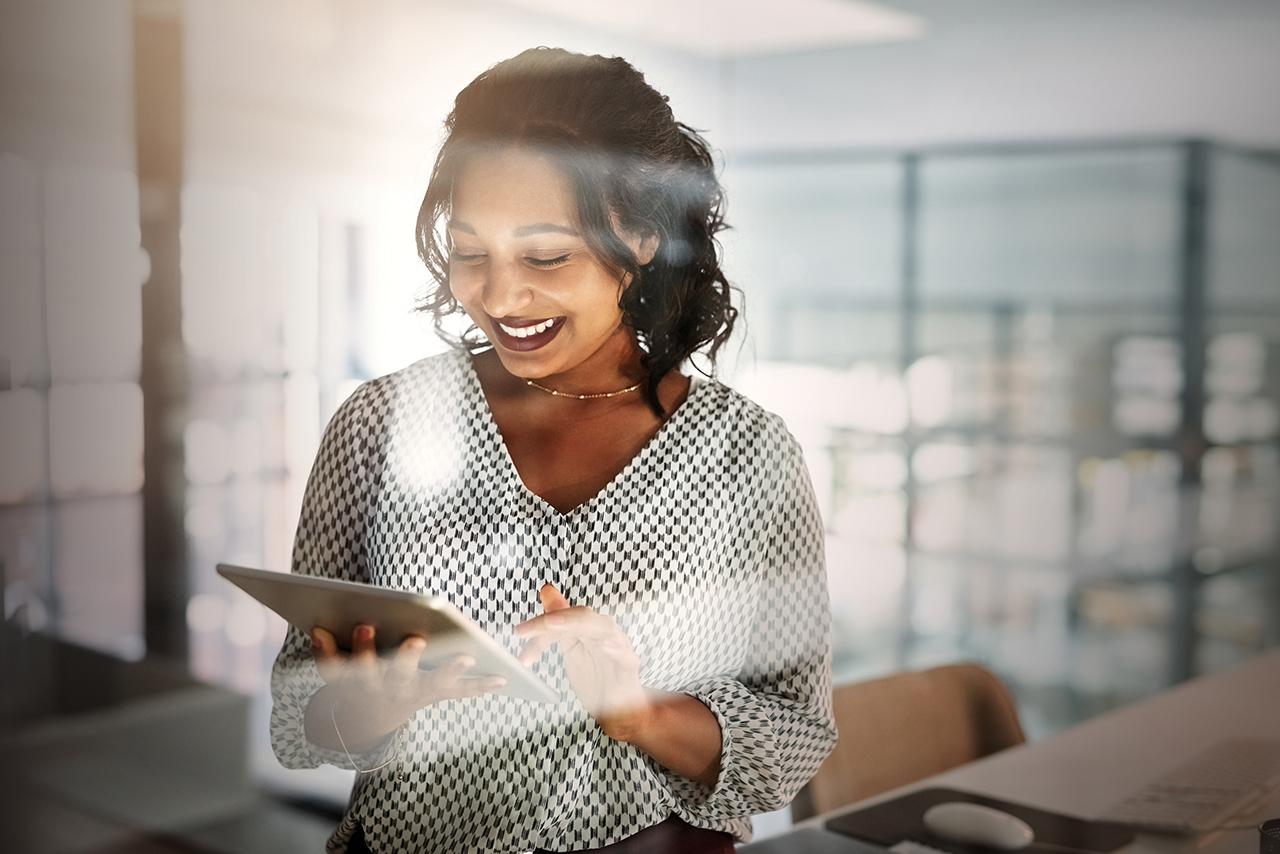 Shot of a young businesswoman using a digital tablet in an office at night